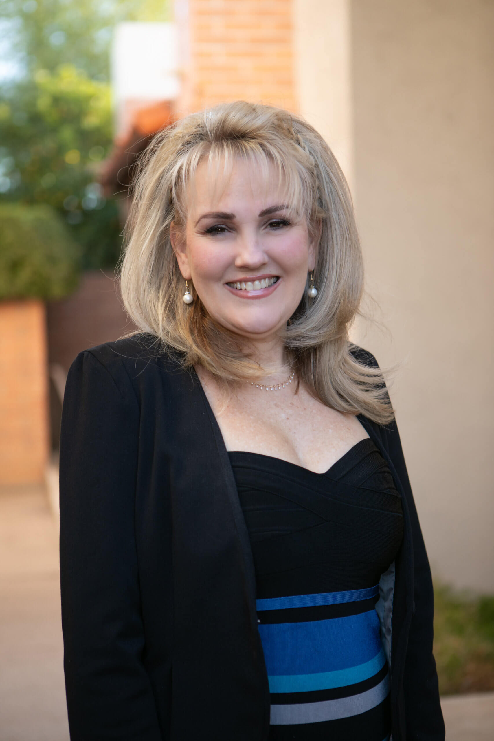 A blond woman is standing in front of a family law office in Tucson, Arizona